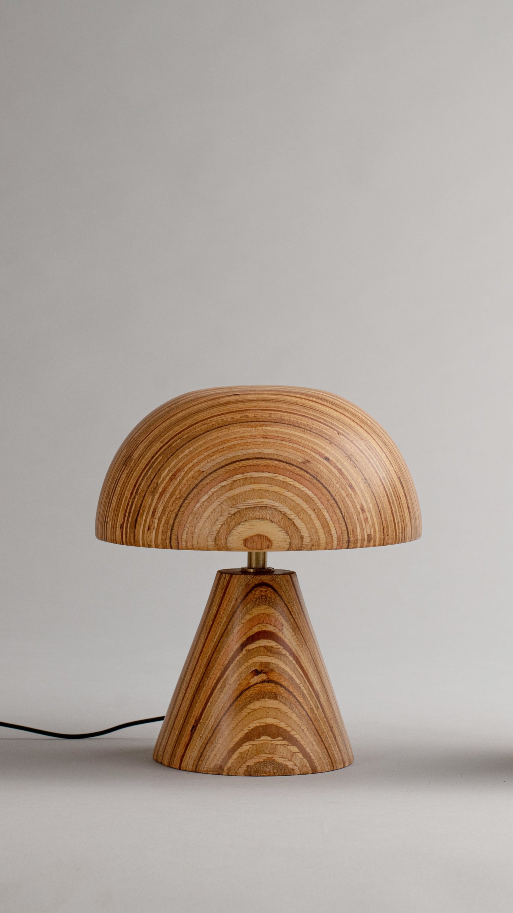Three wooden table lamps with a wavy wood grain pattern on a neutral background