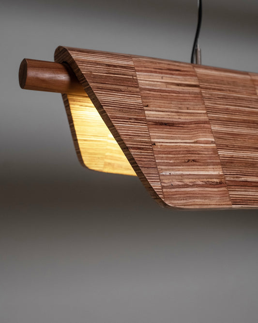 Wooden pendant light with a warm glow on a gray background