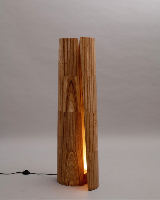 Wooden floor lamp with a cylindrical design on a plain background